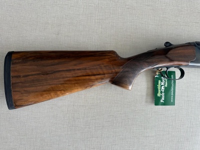 Espingarda com coronha de madeira e etiqueta verde ao gatilho
