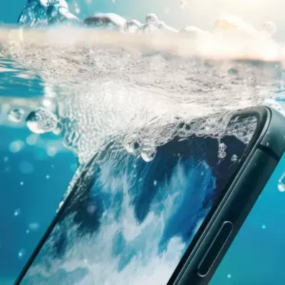 Smartphone preto parcialmente submerso em água com bolhas