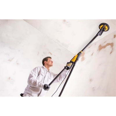 Pessoa a usar lixadeira elétrica de parede comprida