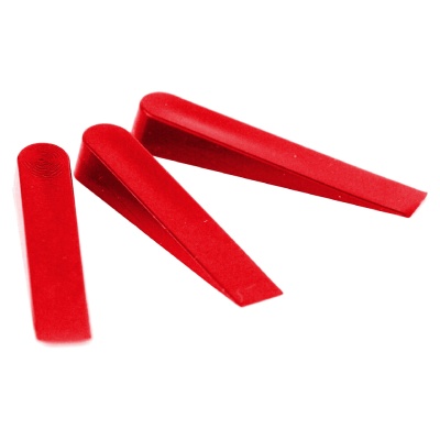 Três peças vermelhas de plástico triangulares sobre fundo branco