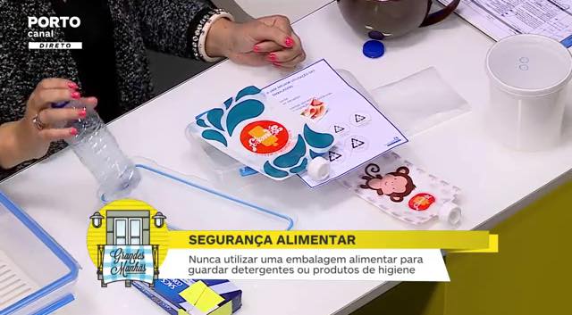 Mãos com garrafa plástica e embalagens com texto de segurança alimentar sobre mesa branca
