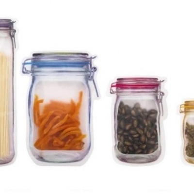 Quatro frascos de vidro transparentes com tampas coloridas contendo diferentes alimentos.