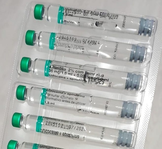 Seis ampolas transparentes com tampa verde em blister