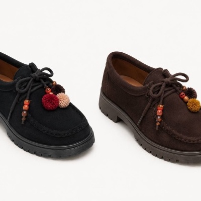 Sapatos mocassins de camurça preto e castanho com pompons e contas de madeira