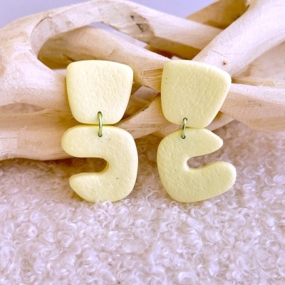 Brincos amarelos claros de cerâmica com forma abstrata