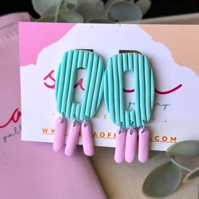 Brincos azuis ovais com pendentes rosa e cartão de apresentação colorido