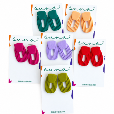 Cinco pares de brincos coloridos em cartões da marca suna