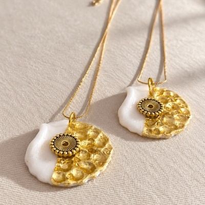 Colares com pendentes redondos em resina branca e dourada com detalhe circular dourado