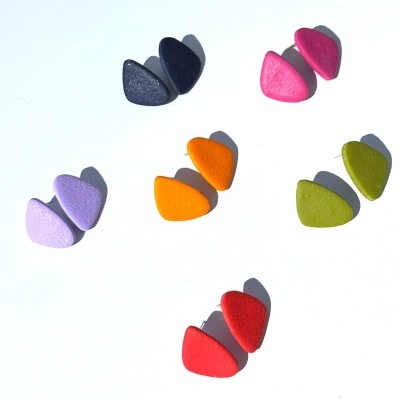 Seis pares de brincos triangulares coloridos sobre fundo branco