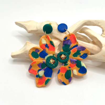 Brincos florais coloridos de material polimérico com centro dourado