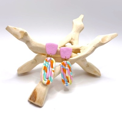 Brincos coloridos com padrão multicolor em suporte natural claro