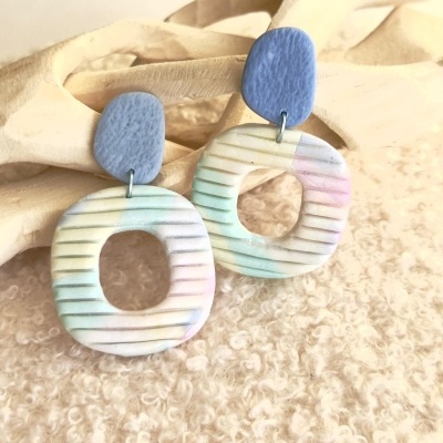 Brincos pendentes com padrão listrado em tons pastel e peça superior azul lisa