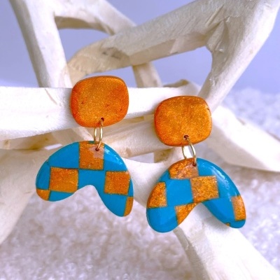 Brincos de resina laranja e azul pendurados