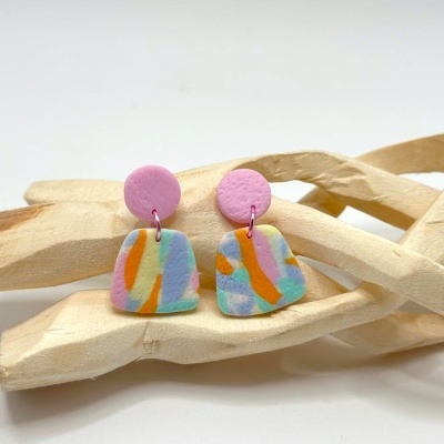 Brincos coloridos pendentes sobre molde de madeira