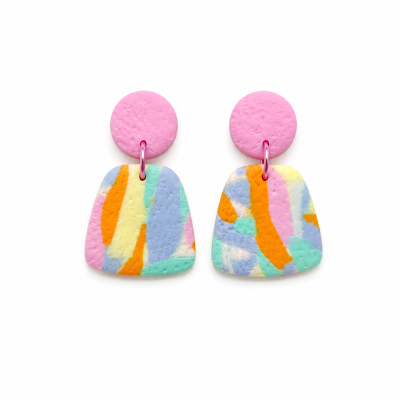 Brincos coloridos pendurados com padrões em rosa, laranja, azul e amarelo