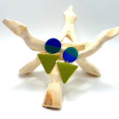 Brincos redondos azul e verde escuro com triângulo verde oliva em suporte de madeira clara