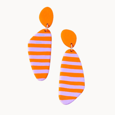 Brincos pendentes laranja com riscas lilás em fundo branco