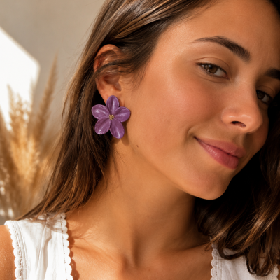 Brincos flor roxa em mulher com blusa branca e cabelo castanho