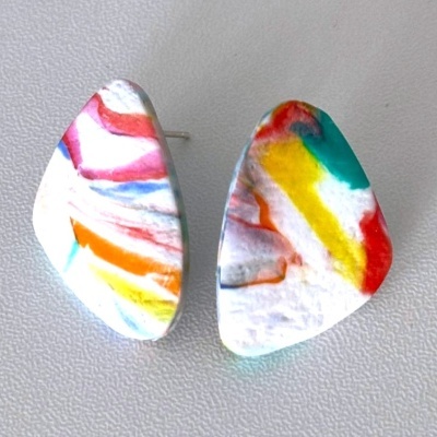 Brincos coloridos com padrão abstrato sobre fundo branco