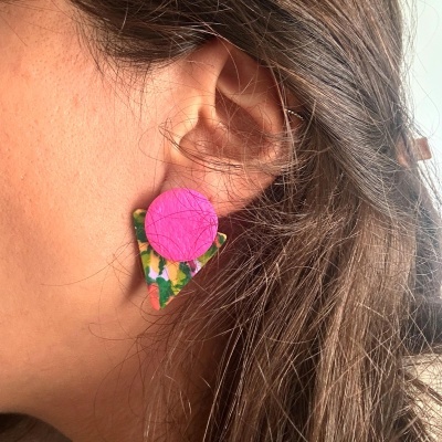 Brinco geométrico rosa e multicolorido em orelha de mulher