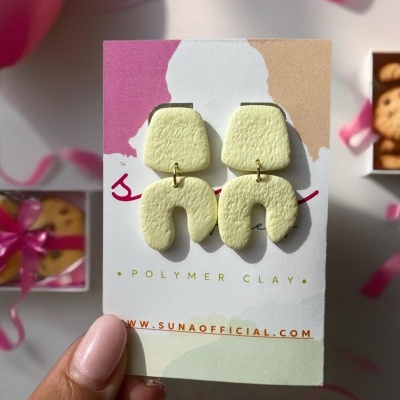 Brincos amarelos de polymer clay com cartão de marca