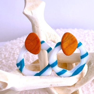 Brincos círculos irregulares com madeira castanha e resina branca com riscas azuis