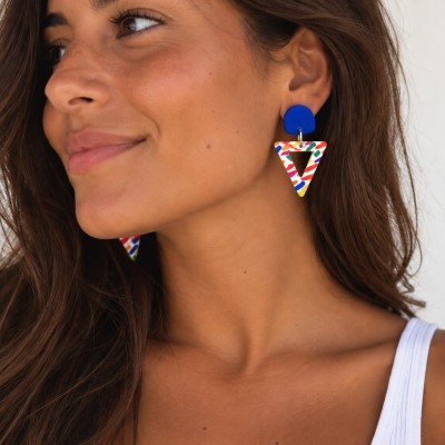 Brincos azuis e multicolores triangulares usados por mulher.
