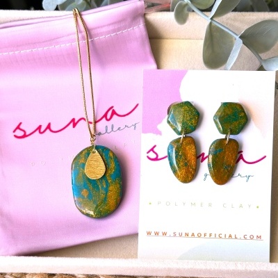Conjunto de colar e brincos azuis e dourados em clay polimérico com embalagem rosa