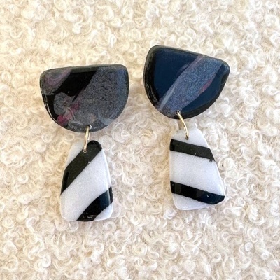 Brincos em polímero preto e branco sobre tecido felpudo branco