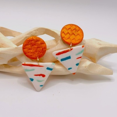 Brincos de resina laranja e branco com padrões coloridos pequenos