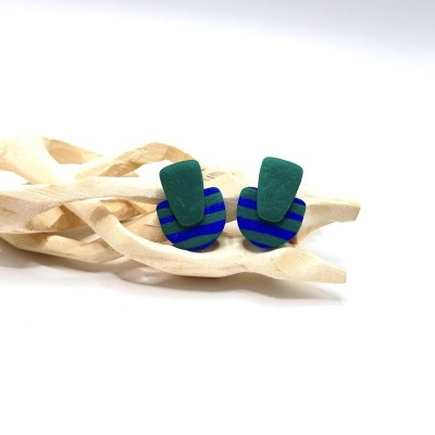 brincos verdes e azuis sobre madeira decorativa clara