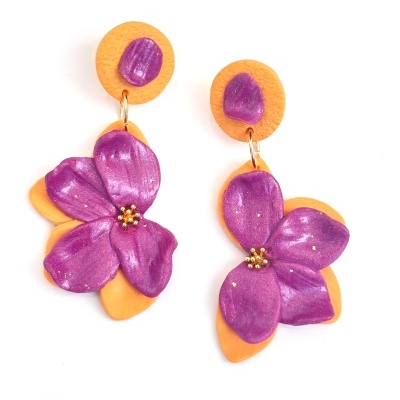 Brincos pendentes com flor roxa e base laranja em fundo branco