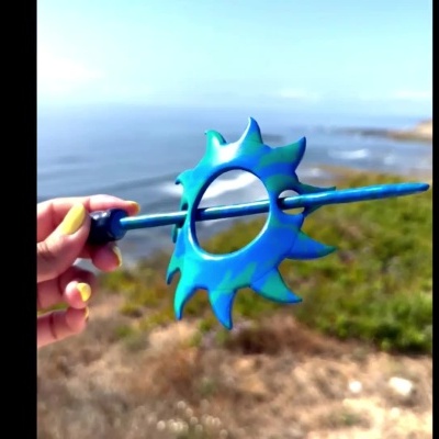 Acessório azul e verde em forma de sol com fundo de mar