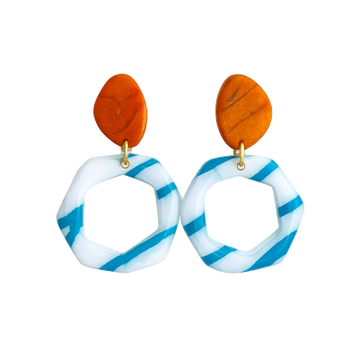 Par de brincos geométricos laranja e branco com riscas azuis.