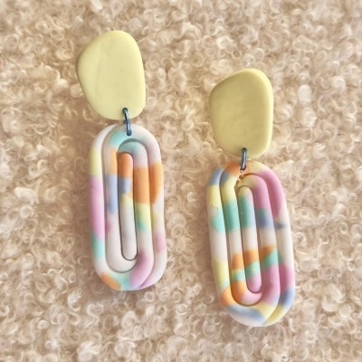 brincos ovais coloridos em massa polimérica em fundo creme texturizado