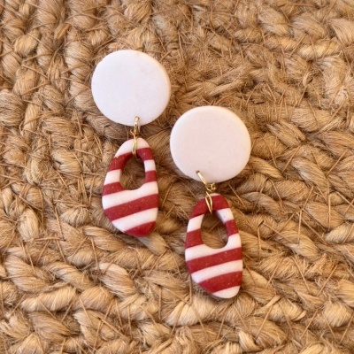 Brincos brancos e vermelhos sobre superfície de fibra natural