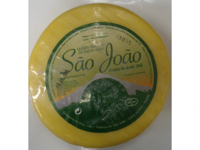 Queijo curado de pasta mole São João com rótulo verde em embalagem redonda amarela