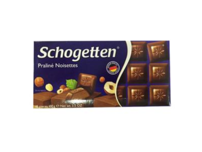 Embalagem azul de chocolate Schogetten Praliné Noisettes com imagem de pedaços de chocolate e avelãs