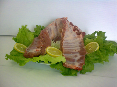 Costelas de carne crua com alface e fatias de limão