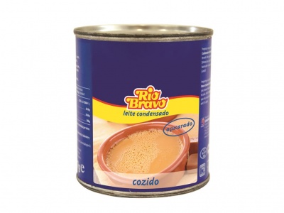 Lata de leite condensado Rio Bravo açucarado cozido com rótulo azul e amarelo