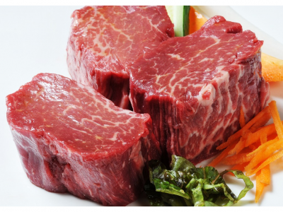 Carne vermelha crua com salada e legumes num prato branco