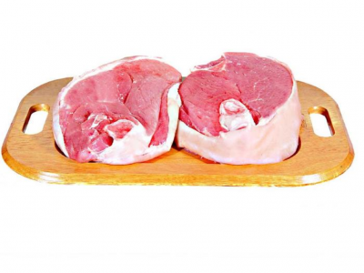 Duas peças de carne crua vermelha numa tábua de madeira