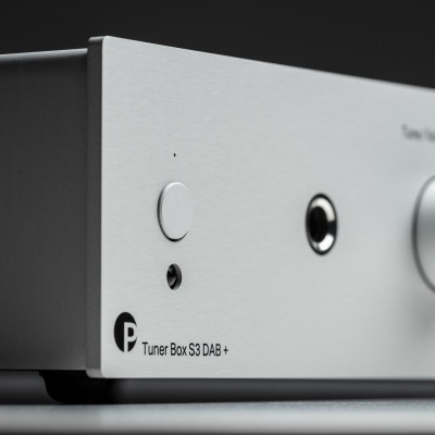 Equipamento eletrónico prateado com botão branco e texto Tuner Box S3 DAB +