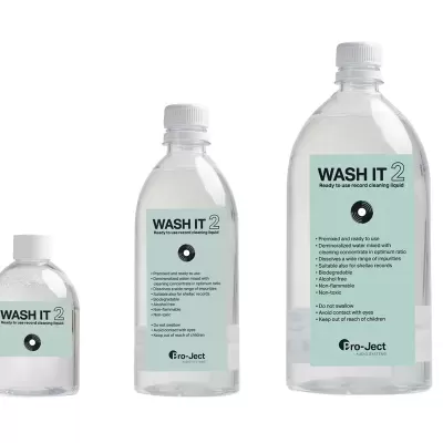 Três frascos transparentes de plástico com líquido e etiquetas verdes