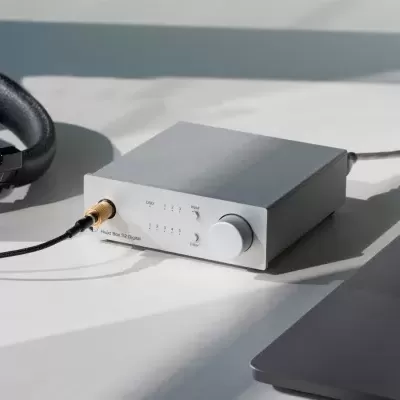 Amplificador de áudio cinza claro com auscultadores pretos e portátil