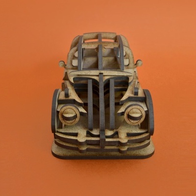 Modelo de carro antigo em madeira clara com detalhes em preto sobre fundo laranja