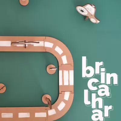 Pista de corrida de cartão com carros de papelão sobre fundo verde