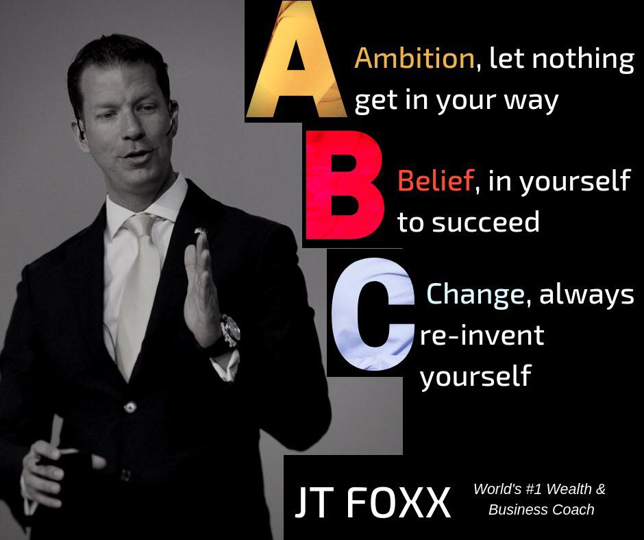 Homem vestido de terno preto e gravata branca ao lado de texto ABC com palavras motivacionais e nome JT FOXX.