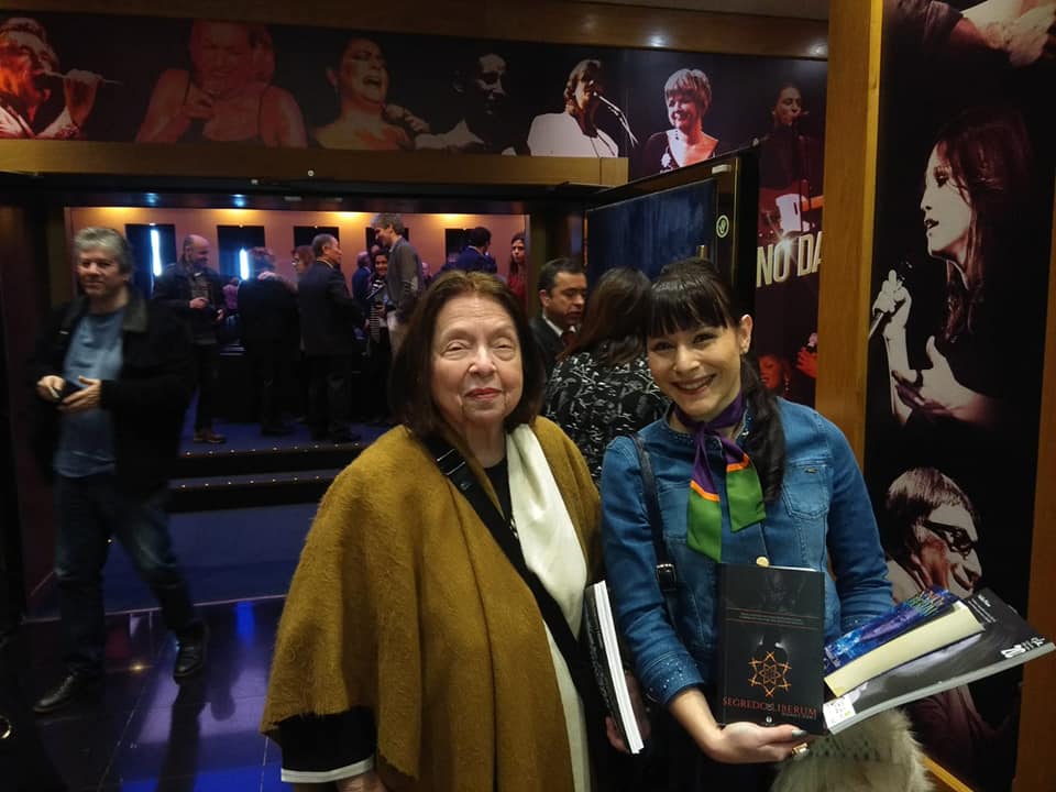 Segredo de Liberum e a escritora FANTÁSTICA Nélida Piñon Duas mulheres em interior com paredes decoradas com fotos de músicos