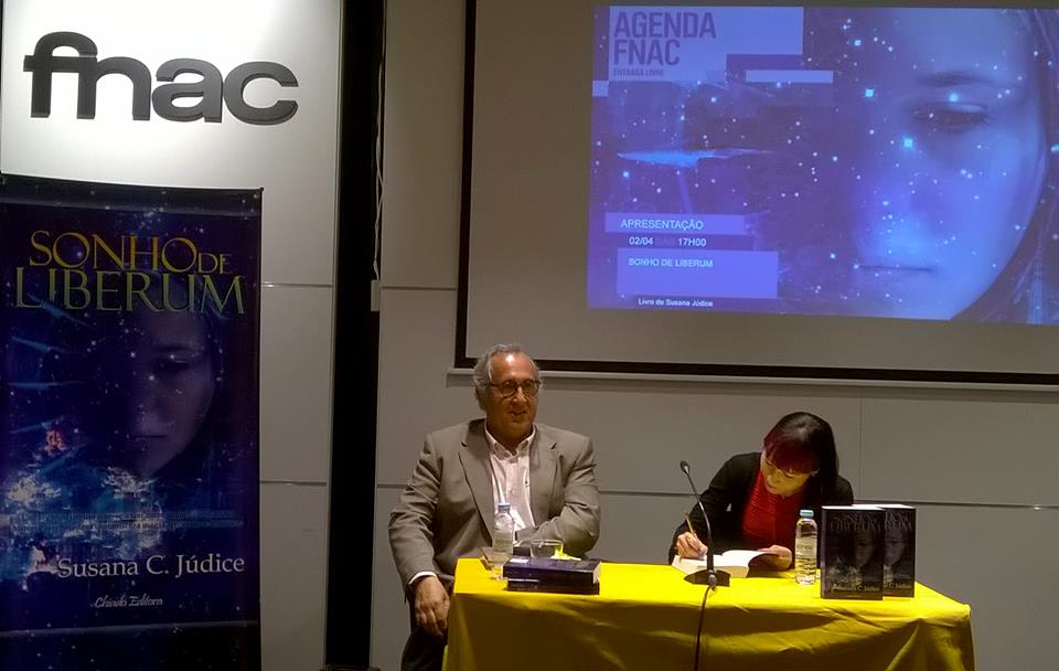 Evento FNAC com autor a assinar livros, cartaz do livro Sonho de Liberum e ecrã de apresentação